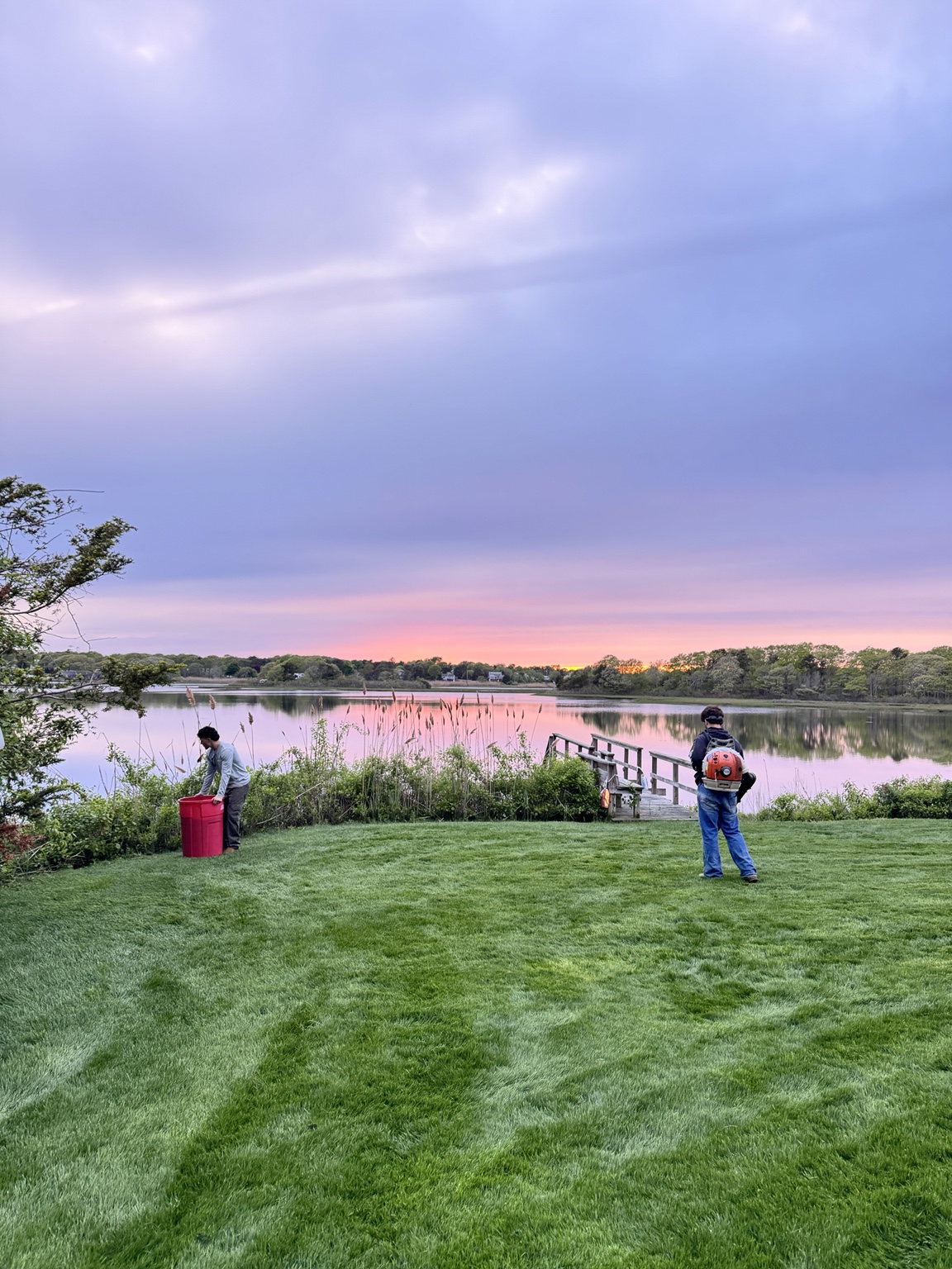 GB Landscape crew finishing a waterfront lawn at sunset